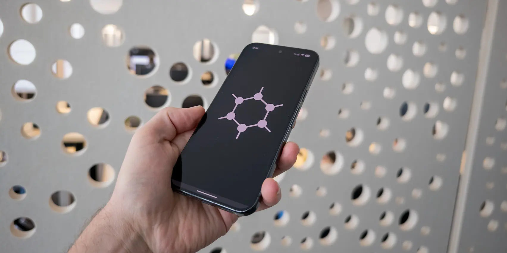 A GrapheneOS Pixel held in one hand, screen on, in everyday use
